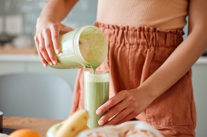 une femme versant un smoothie détox dans un verre